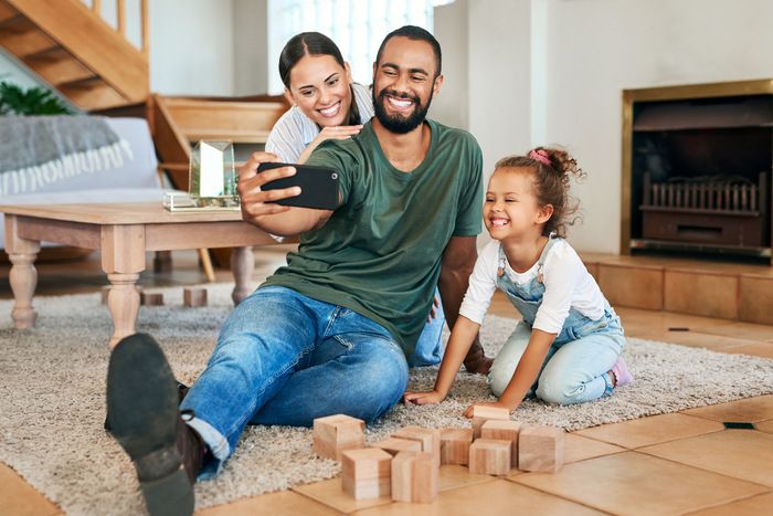Shot of a happy family taking selfies together at home.